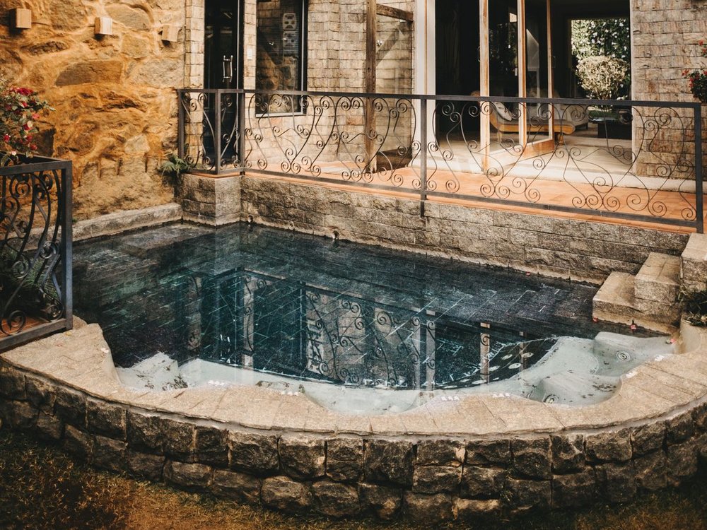 Stone retaining wall structurally supporting an elevated pool