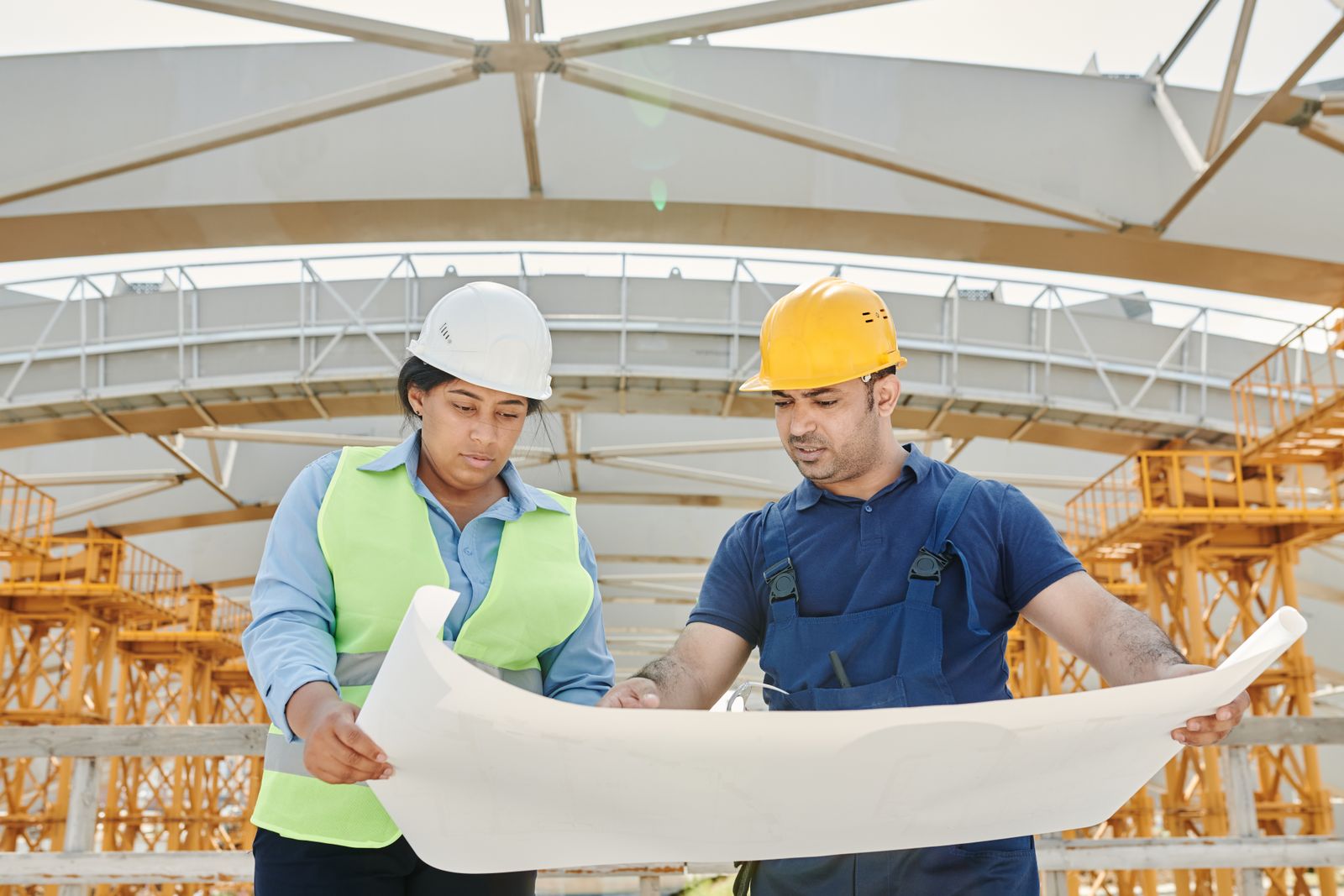 Two engineers reviewing structural drawings on site